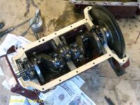 Pistons assembled to crankshaft, all bearing caps in place, timing chain assembled and flywheel bolted up. Sump gaskets placed on block.